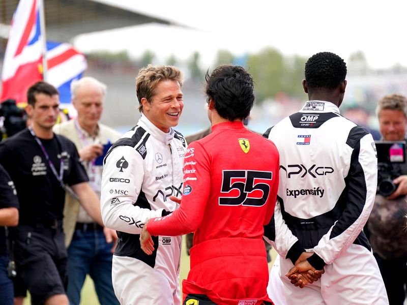 Brad Pitt (l, im Gespräch mit Fahrer Carlos Sainz) und Damson Idris (r) sind auf der Formel-1-Strecke in Silverstone mit von der Partie. - Foto: Tim Goode/PA Wire/dpa