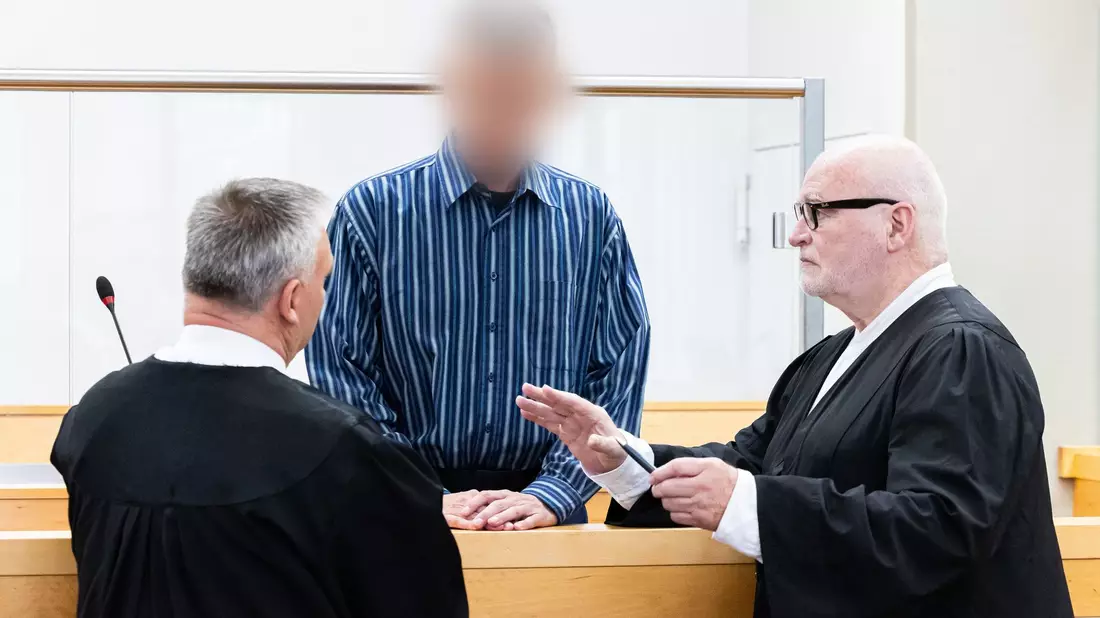 Der Angeklagte (M) vor Prozessbeginn im Landgericht Hannover. - Bild: Michael Matthey/dpa