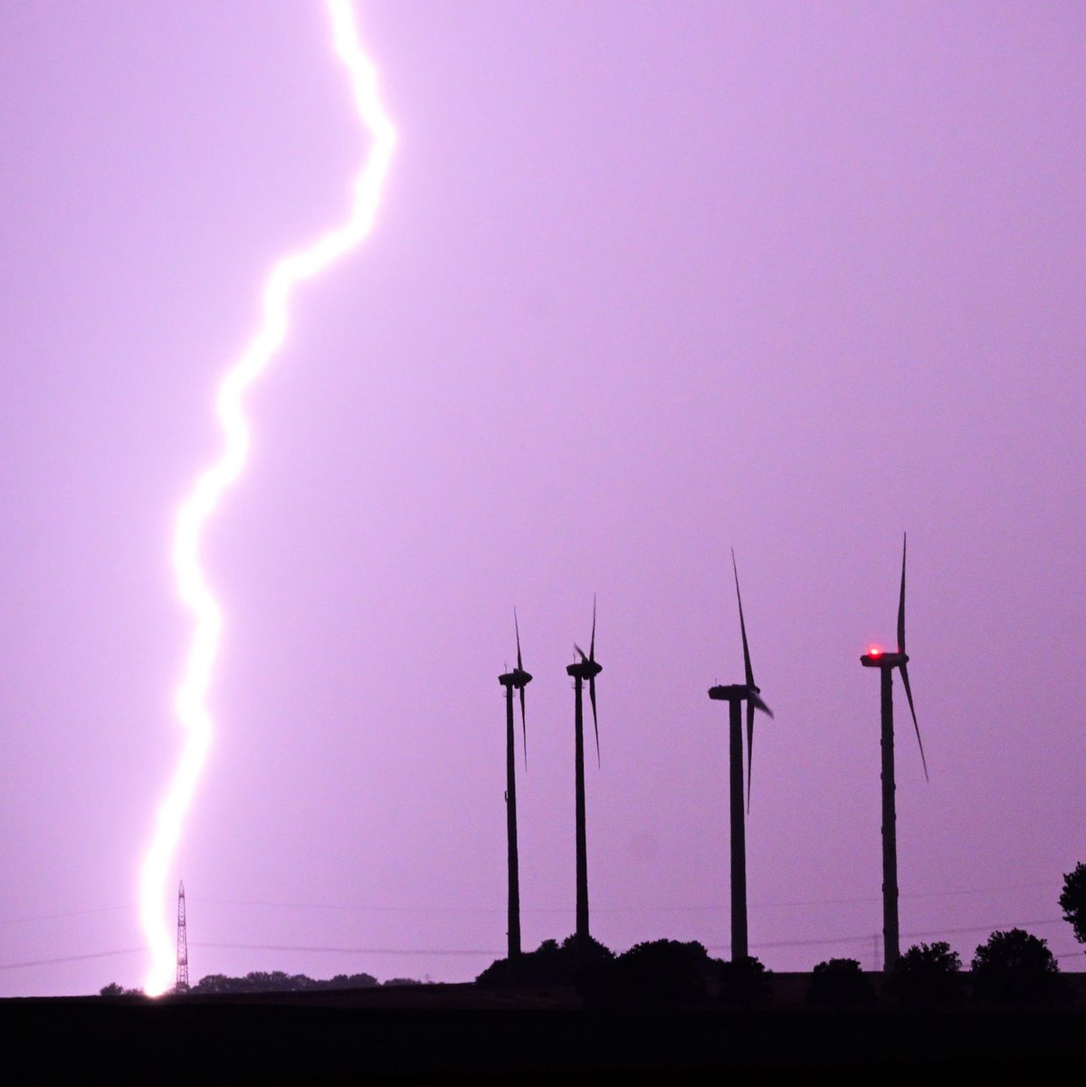Ein Blitz entlädt sich während eines Gewitters hinter dem Fernmeldeturm Telemax. - Foto: Julian Stratenschulte/dpa