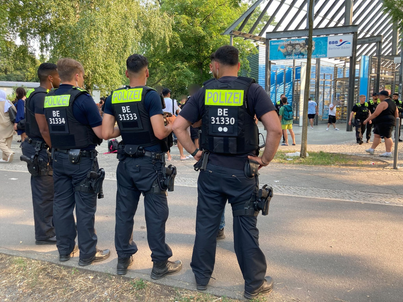 Polizisten stehen vor dem Eingang des Sommerbads in Neukölln. - Foto: Carioline Bock/dpa
