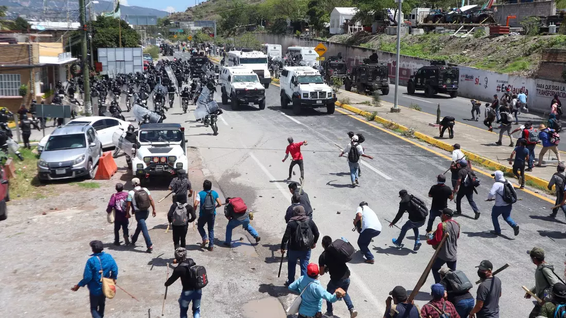 Sicherheitskräfte werden auf einer Autobahn in Chilpancingo von Demonstranten mit Steinen beworfen. - Bild: Eduardo Guerrero Ramirez/dpa