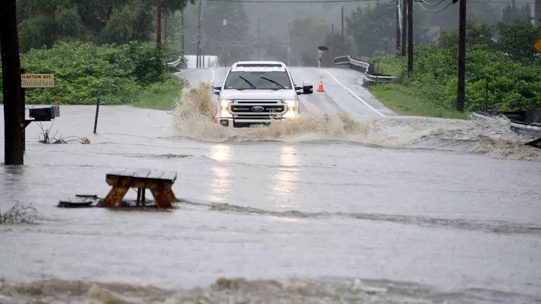 Ein Auto fährt über eine überschwemmte Straße im US-Bundesstaat Vermont. Gouverneur Phil Scott nennt die Situation «historisch und katastrophal». - Bild: Jeb Wallace-Brodeur/The Times Argus/AP/dpa
