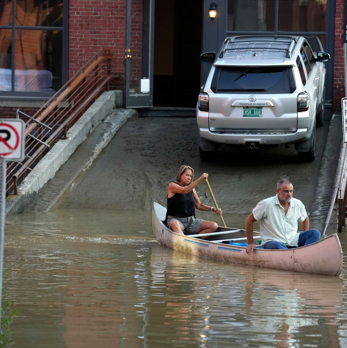 Ein Tierarzt und seine Mitarbeiterin transportieren per Kanu chirurgisches Material aus der von der Flut beschädigten Tierklinik in Montpelier. - Foto: Steven Senne/AP