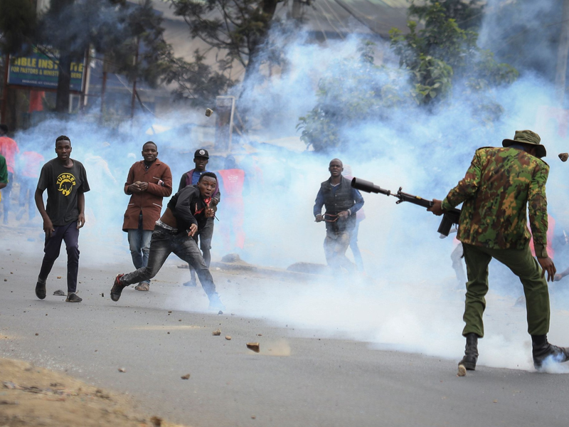 Zusammenstoß im Mathare-Viertel in Nairobi: Steine werfende Demonstranten und Polizisten, die Tränengas abfeuern. - Foto: AP/dpa