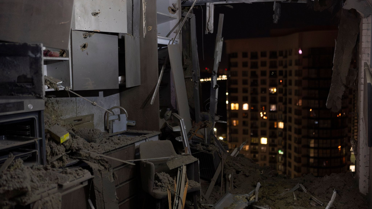 Anwohner stehen vor einem Wohnhaus in Kiew, das bei russischen Luftangriffen beschädigt wurde. - Foto: Jae C. Hong/AP