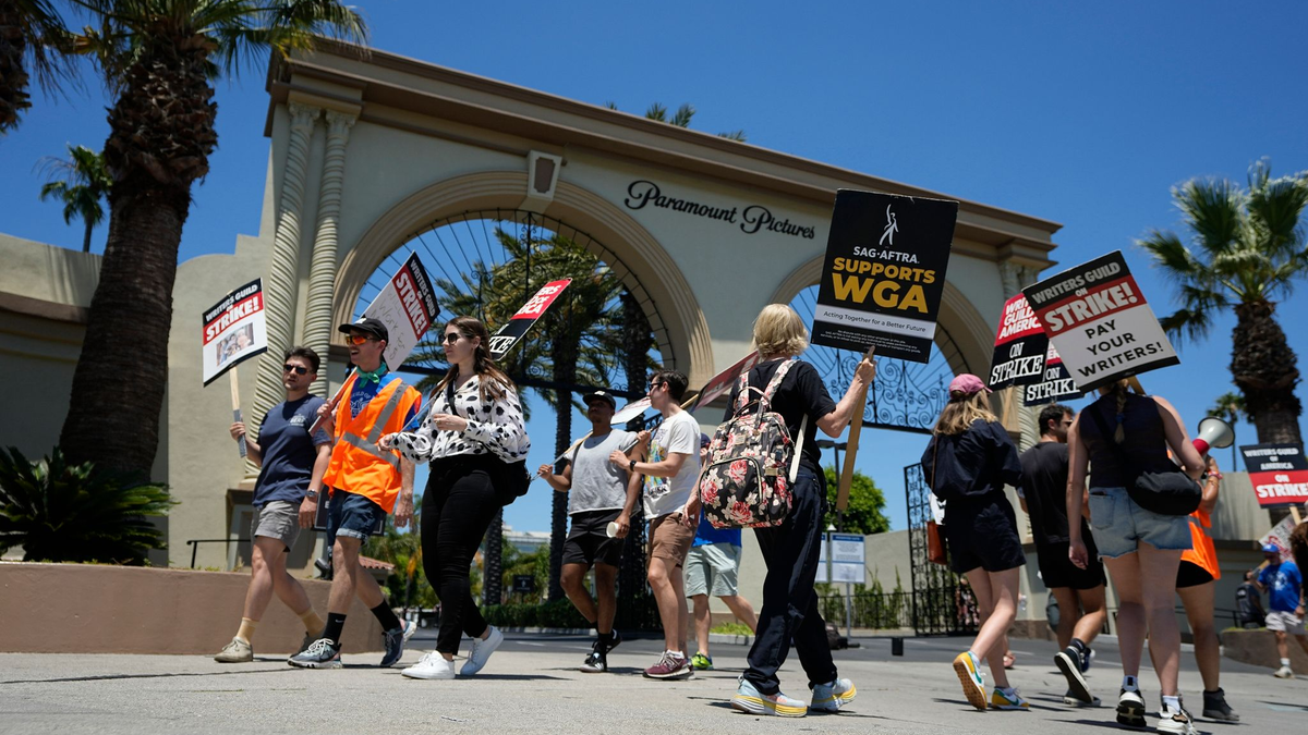 Ein Demonstrant wählt während einer Kundgebung in Los Angeles sein Schild zum Streiken aus. - Foto: Mark J. Terrill/AP