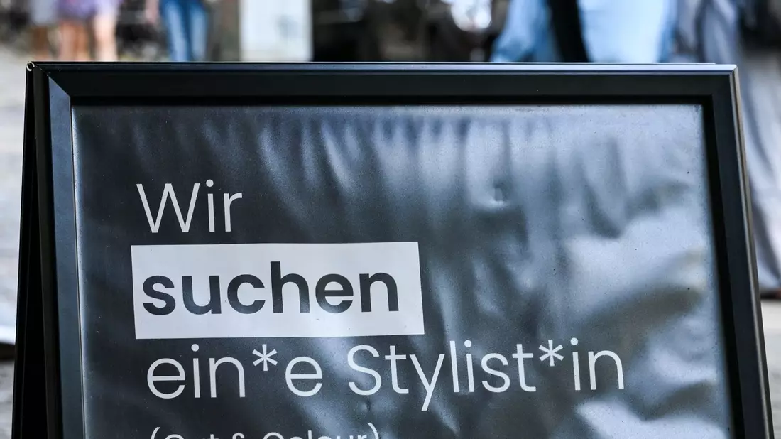 Auf einem Schild wird gendergerecht eine Stylistin beziehungsweise ein Stylist gesucht. - Bild: Jens Kalaene/dpa