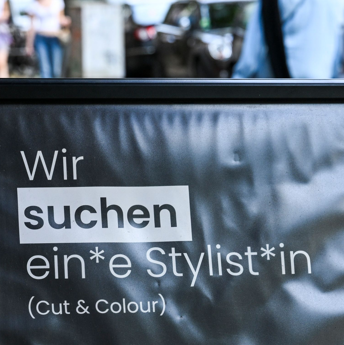 Auf einem Schild wird gendergerecht eine Stylistin beziehungsweise ein Stylist gesucht. - Foto: Jens Kalaene/dpa