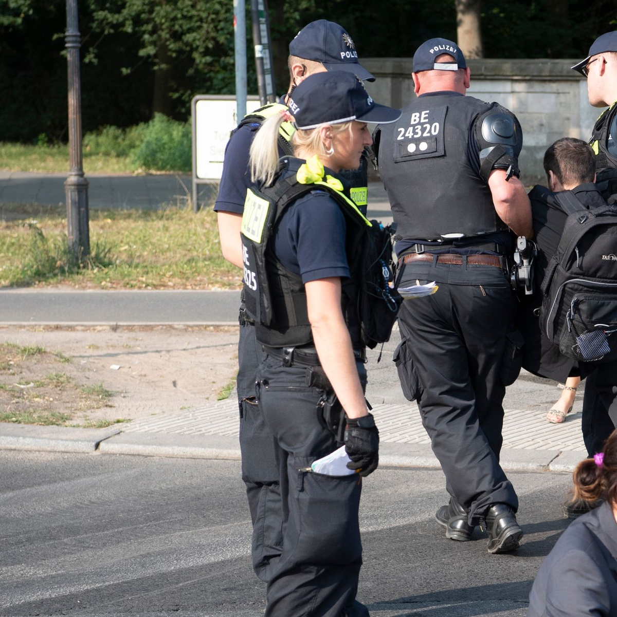 Die Polizei trägt einen Aktivisten der Gruppe Letzte Generation weg, der mit anderen die Fahrbahnen rund um die Siegessäule in Berlin blockiert hat. - Foto: Paul Zinken/dpa