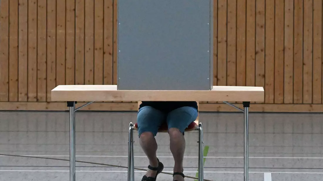 Eine Frau gibt in einem Wahllokal ihre Stimme ab. - Bild: Martin Schutt/dpa