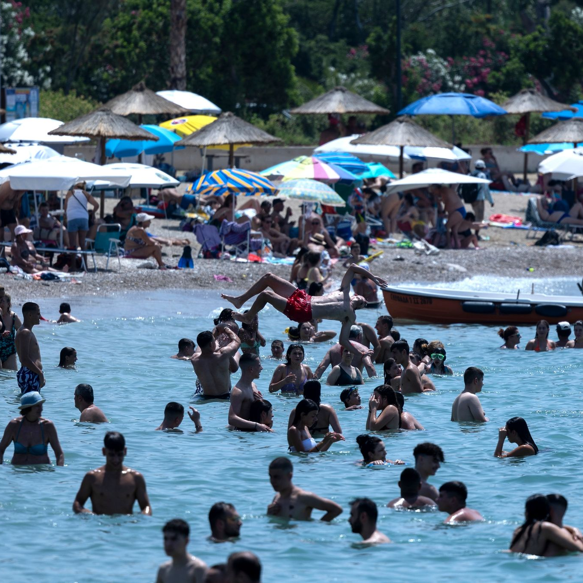 Ein Strandbesucher kühlt sich unter einer Dusche im Vorort Alimos in Athen ab. - Foto: Yorgos Karahalis/AP/dpa