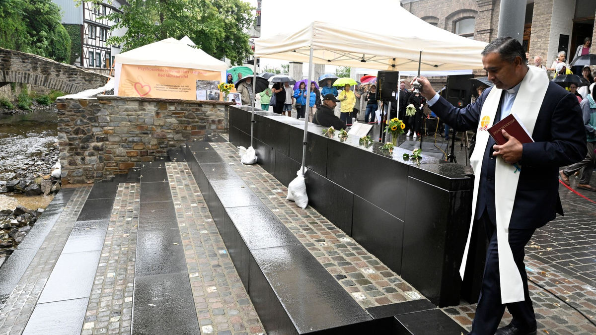 Pfarrer Robert Rego segnet eine Freitreppe an der Erft. - Foto: Roberto Pfeil/dpa