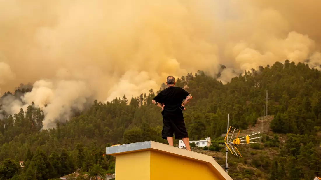 Drei Männer beobachten den Waldbrand auf der Kanareninsel. - Bild: Europa Press/EUROPA PRESS/dpa