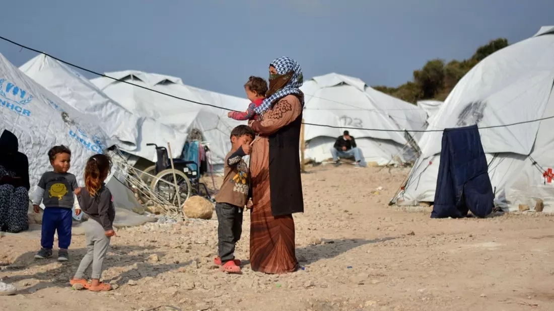 Eine Frau steht mit ihren Kindern im Flüchtlingslager Kara Tepe in der Nähe von Mytilini auf Lesbos (Symbolbild). - Bild: Panagiotis Balaskas/AP/dpa