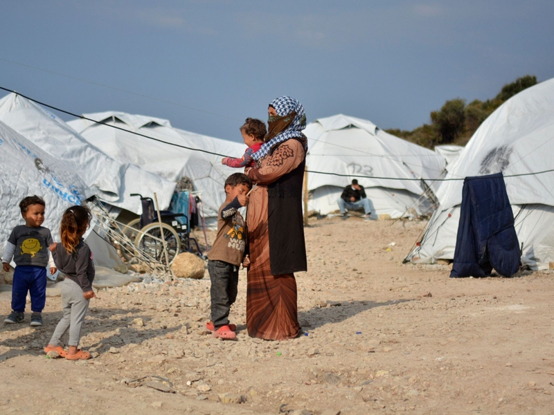 Eine Frau steht mit ihren Kindern im Flüchtlingslager Kara Tepe in der Nähe von Mytilini auf Lesbos (Symbolbild). - Foto: Panagiotis Balaskas/AP/dpa