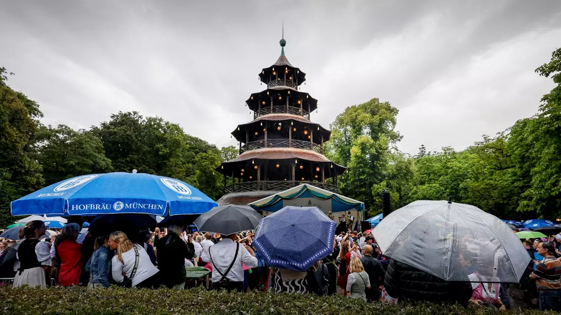 Kocherlball am Chinesischen Turm in Münchens Englischem Garten: Das Wetter hat es nicht so gut gemeint mit den Frühaufstehern. - Bild: Uwe Lein/dpa