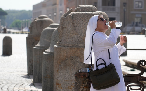 Eine Nonne erfrischt sich auf dem Petersplatz mit einem Schluck aus der Wasserflasche. - Foto: Gregorio Borgia/AP/dpa