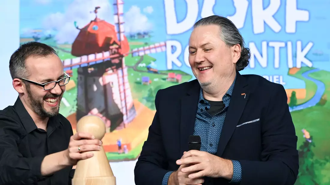 Die Spieleentwickler Lukas Zach und Michael Palm freuen sich über die Wahl ihres Spiels «Dorfromantik: Das Brettspiel» zum «Spiel des Jahres 2023». - Bild: Jens Kalaene/dpa