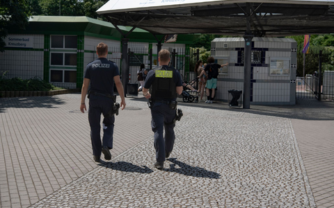 Zwei Polizsten der Mobilen Wache gehen auf das Prinzenbad in Kreuzberg zu. - Foto: Paul Zinken/dpa