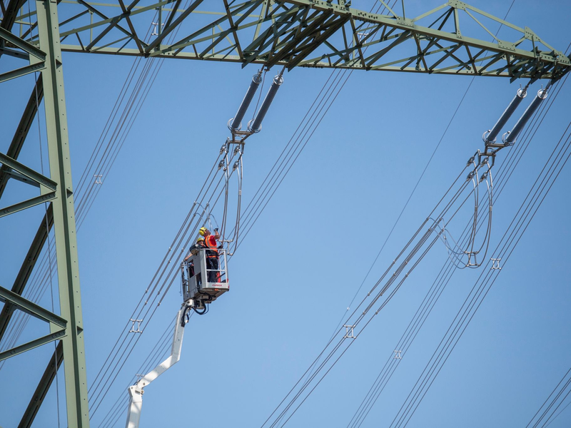 In einem Umspannwerk in Brandenburg wird an einer Stromleitung gearbeitet (Symbolbild). Energie ist einer von elf Bereichen, für die im Entwurf des KRITIS-Dachgesetzes besondere Auflagen gemacht werden. - Foto: Christophe Gateau/dpa