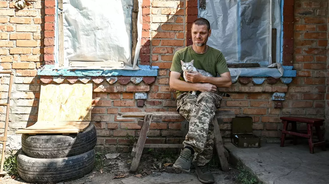 Ein Soldat der Territorialen Verteidigung der Ukraine aus Dnipro legt eine Pause ein - eine Katze leistet ihm Gesellschaft. - Bild: ---/Ukrinform/dpa