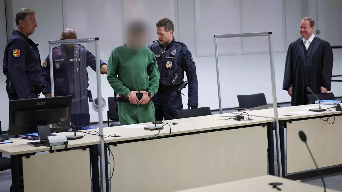 Der Angeklagte Ibrahim A. (3.v.l.) wird in den Gerichtssaal gebracht. - Bild: Christian Charisius/dpa/Pool/dpa
