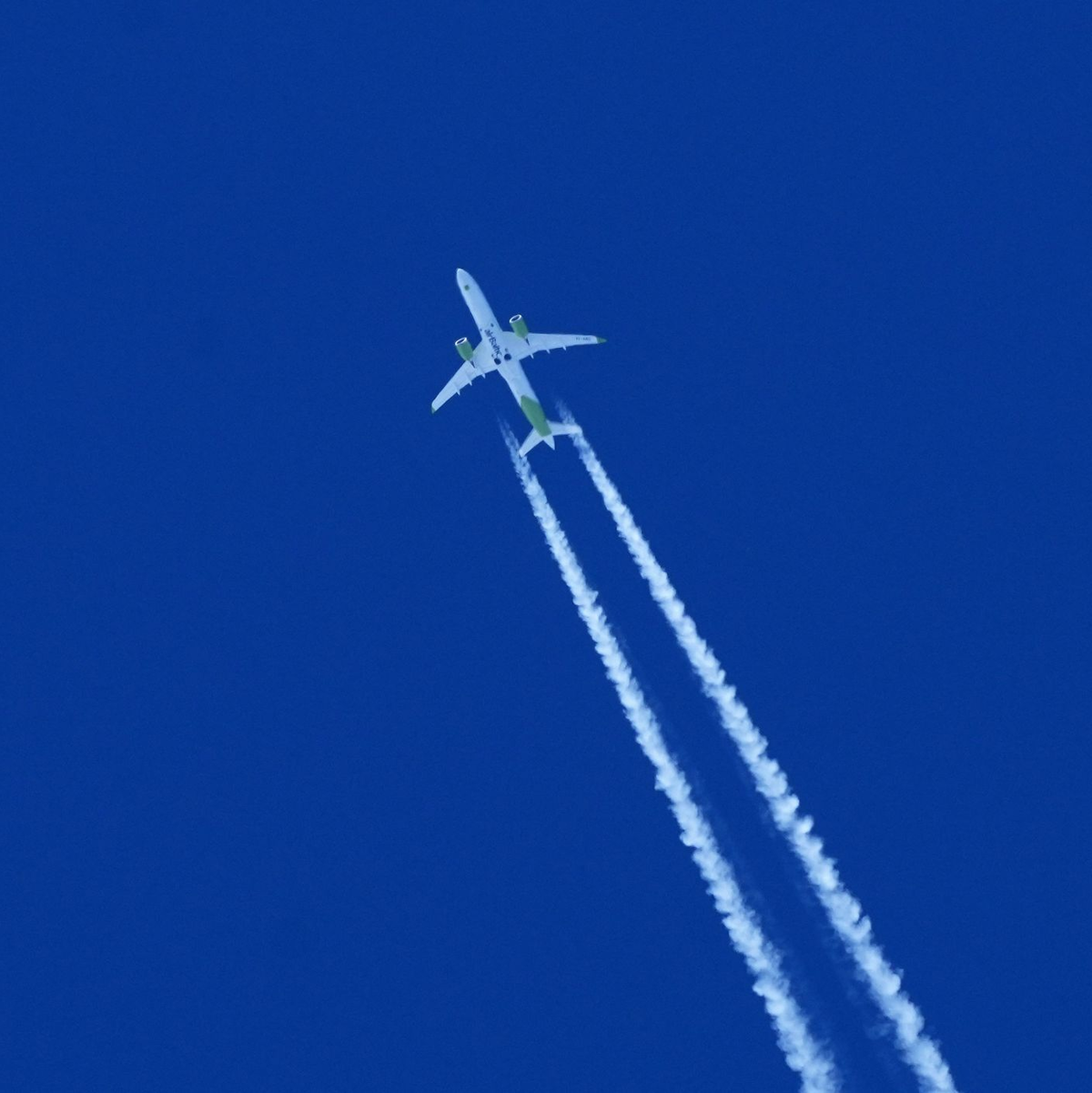 Ein Flugzeug zieht am Himmel einen Kondensstreifen hinter sich her. - Foto: Soeren Stache/dpa