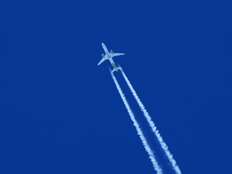 Ein Flugzeug zieht am Himmel einen Kondensstreifen hinter sich her. - Foto: Soeren Stache/dpa