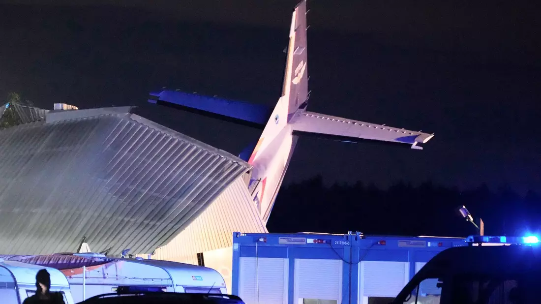 Das Heck einer Cessna 208B vom Typ «Grand Caravan» ragt aus einem Hangar, in den die Maschine nach dem Landeanflug auf den Sportflughafen Chrcynno nördlich der Hauptstadt Warschau gekracht ist. - Bild: Czarek Sokolowski/AP/dpa
