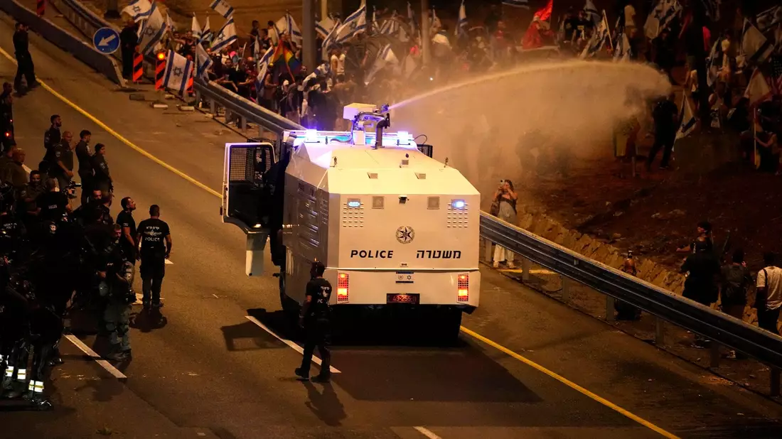 Die Polizei setzt einen Wasserwerfer ein, um Demonstranten zu zerstreuen, die in Tel Aviv demonstrieren. - Bild: Ariel Schalit/AP