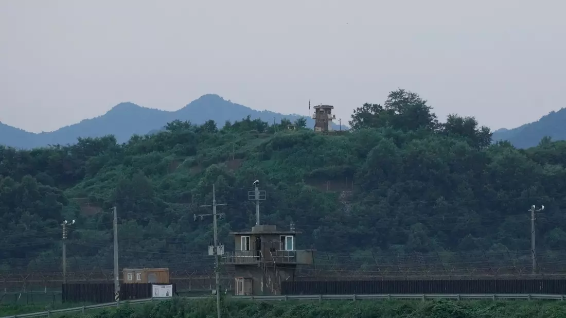 Ein nordkoreanischer Wachposten (hinten) und ein südkoreanischer Wachposten (vorne) an der innerkoreanischen Grenze. - Bild: Ahn Young-joon/AP/dpa