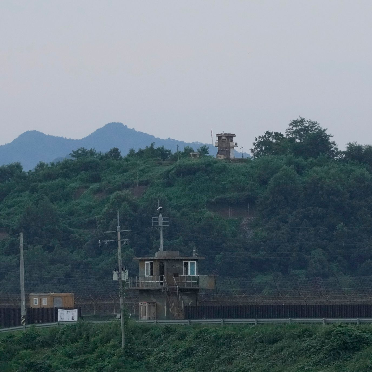 Ein nordkoreanischer Wachposten (hinten) und ein südkoreanischer Wachposten (vorne) an der innerkoreanischen Grenze. - Foto: Ahn Young-joon/AP/dpa