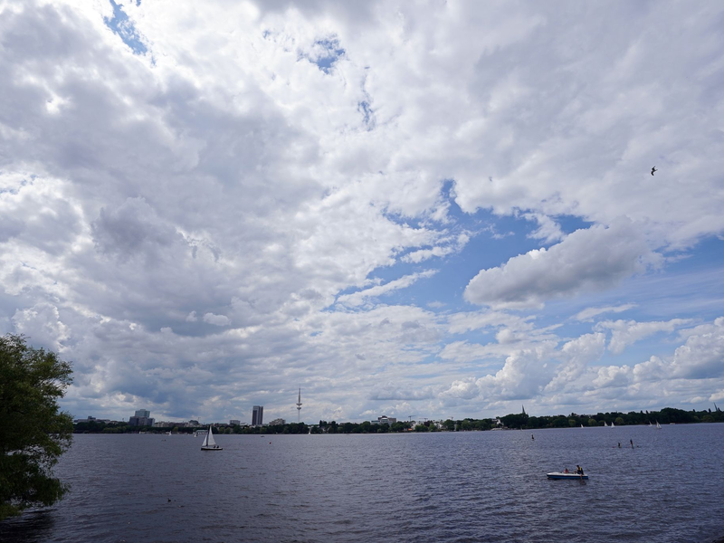 Dichte Wolken ziehen über die Segelboote und Tretboote auf der Außenalster hinweg. - Foto: Marcus Brandt/dpa