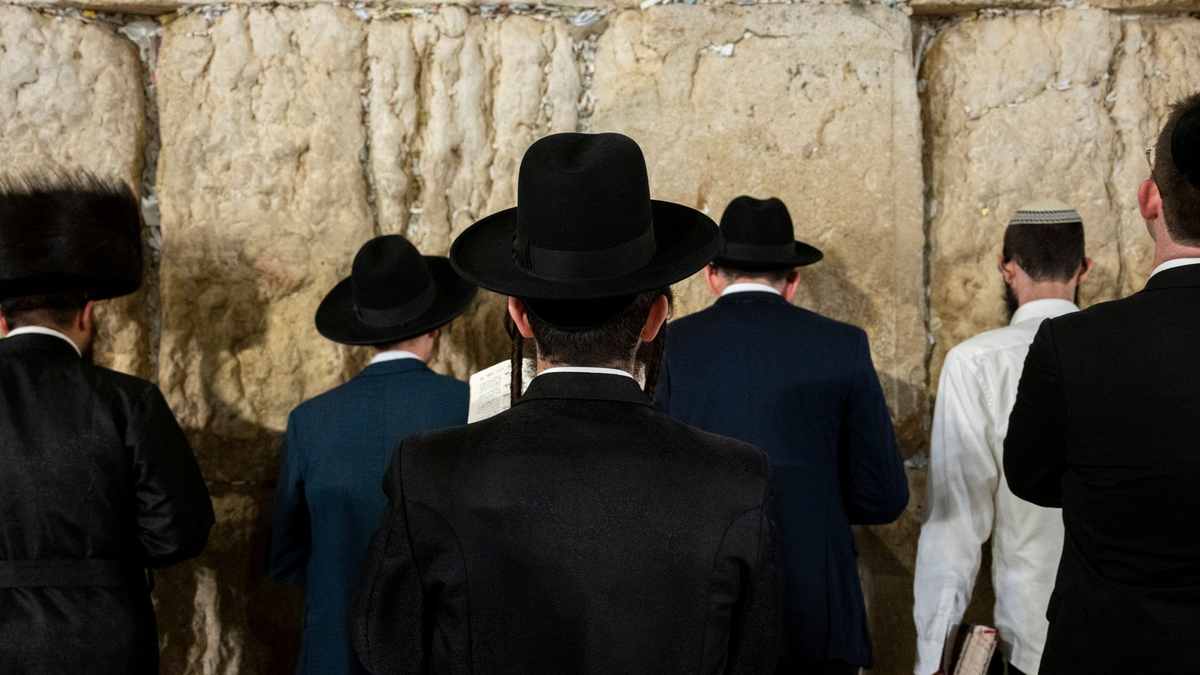 Ultraorthodoxe jüdische Männer beten an der Klagemauer. - Foto: Christophe Gateau/dpa