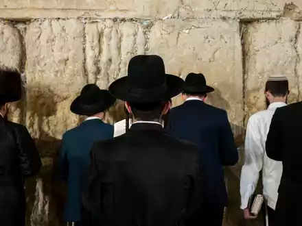 Ultraorthodoxe jüdische Männer beten an der Klagemauer. - Foto: Christophe Gateau/dpa