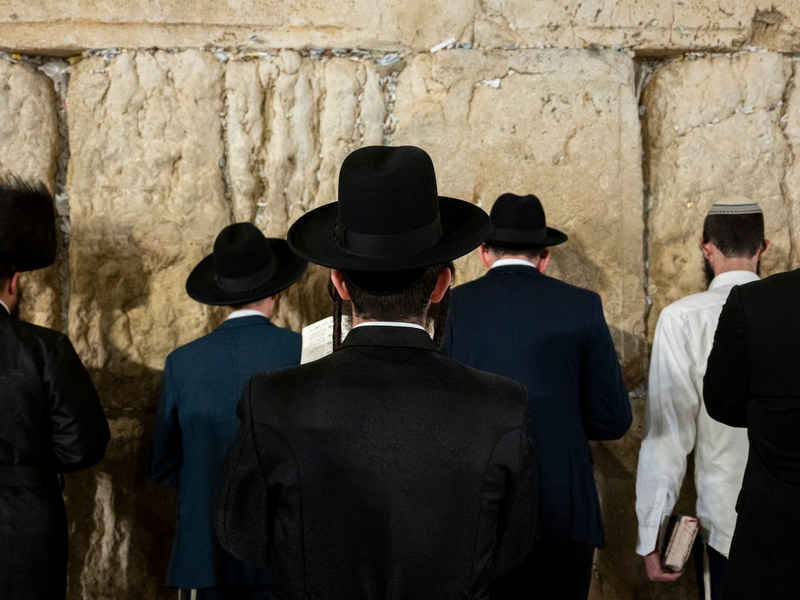 Ultraorthodoxe jüdische Männer beten an der Klagemauer. - Foto: Christophe Gateau/dpa