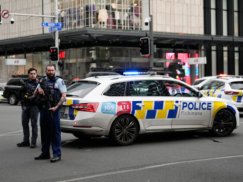 Bewaffnete neuseeländische Polizisten stehen an einer Straßensperre, nachdem in Auckland Schüsse gefallen waren. - Foto: Abbie Parr/AP