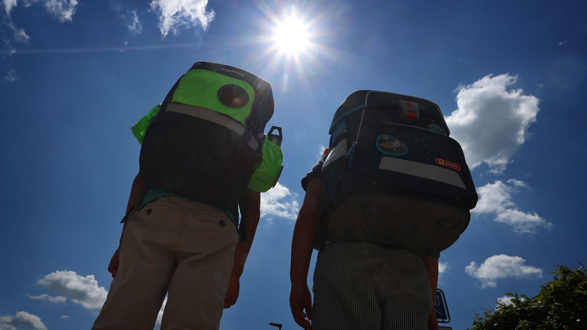 Zwei Kinder laufen mit ihren Schulranzen im Sonnenschein. - Foto: Karl-Josef Hildenbrand/dpa