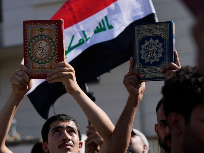 Anhänger des schiitischen Geistlichen Muqtada al-Sadr halten den Koran, das heilige Buch der Muslime, während einer Demonstration vor der schwedischen Botschaft hoch. - Foto: Hadi Mizban/AP