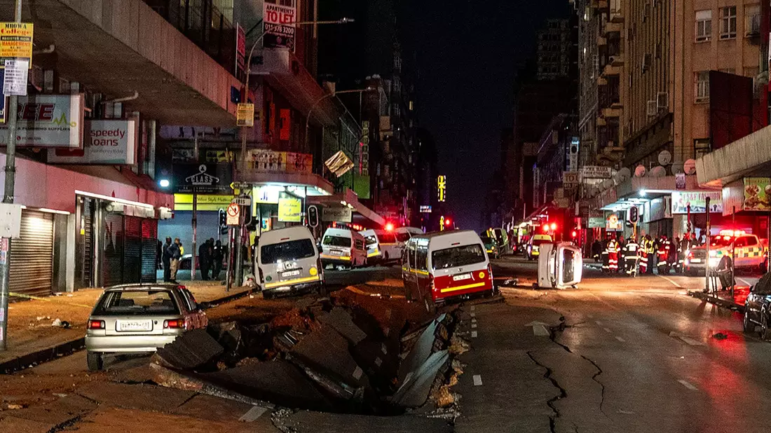 Die mutmaßliche Gasexplosion hat ein Loch in die Straße gerissen. - Bild: Shiraaz Mohamed/AP/dpa