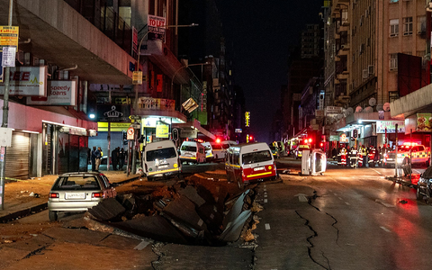 Die mutmaßliche Gasexplosion hat ein Loch in die Straße gerissen. - Foto: Shiraaz Mohamed/AP/dpa