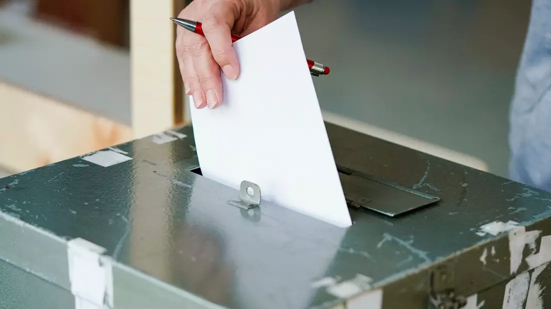Ein Wählerin wirft in einem Wahllokal ihren Stimmzettel in die Wahlurne. - Bild: Uwe Anspach/dpa
