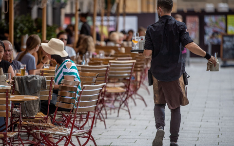 Eine Servicekraft bedient im Außenbereich eines Restaurants die Gäste. - Foto: Christoph Schmidt/dpa