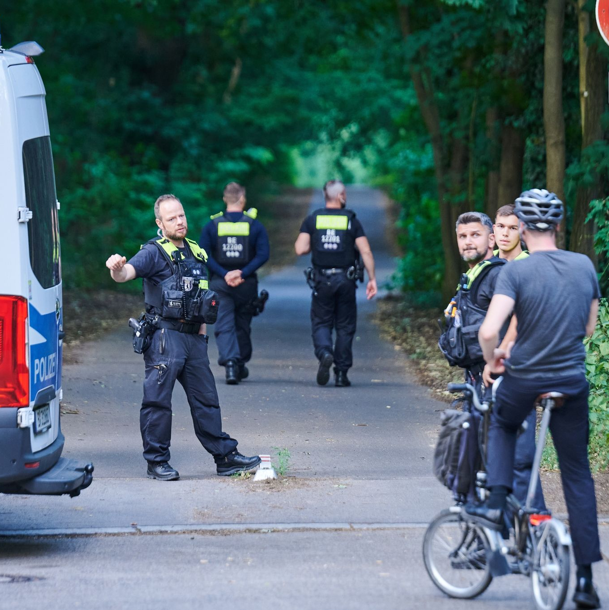 Polizisten stehen am Eingang eines Waldgebietes in dem sich die Raubkatze befinden soll. - Foto: Annette Riedl/dpa