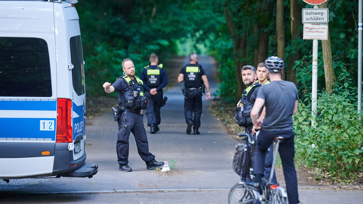 Polizisten stehen am Eingang eines Waldgebietes in dem sich die Raubkatze befinden soll. - Foto: Annette Riedl/dpa