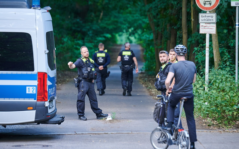 Polizisten stehen am Eingang eines Waldgebietes in dem sich die Raubkatze befinden soll. - Foto: Annette Riedl/dpa