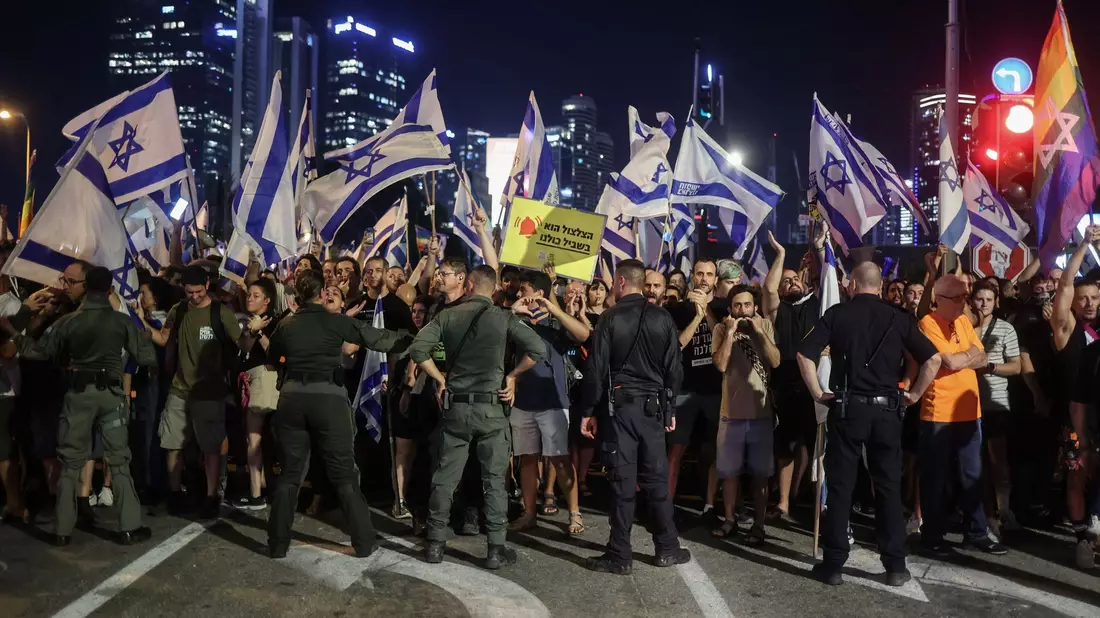 Polizisten stehen vor Demonstranten während eines Protests gegen die israelische Regierung. - Bild: Ilia Yefimovich/dpa
