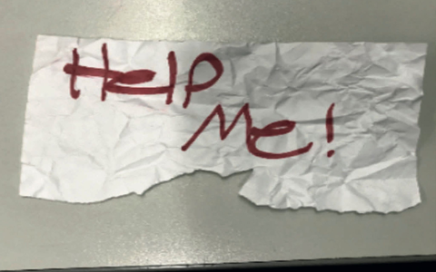 «Hilf mir»: Diese stück Papier hielt das Mädchen aus dem Auto hoch. - Foto: U.S. Department of Justice/AP/dpa