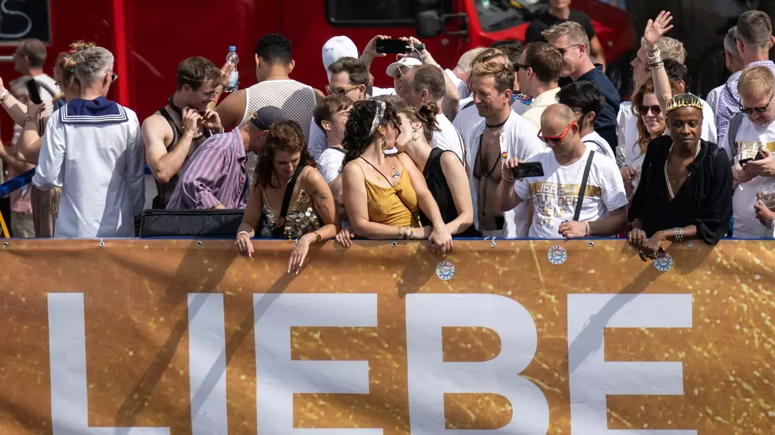 Ein Kuss auf einem der Wagen der Parade. Zwei Frauen zeigen öffentlich ihre Zuneigung zueinander, ohne sich verstecken zu müssen. - Bild: Hannes P. Albert/dpa