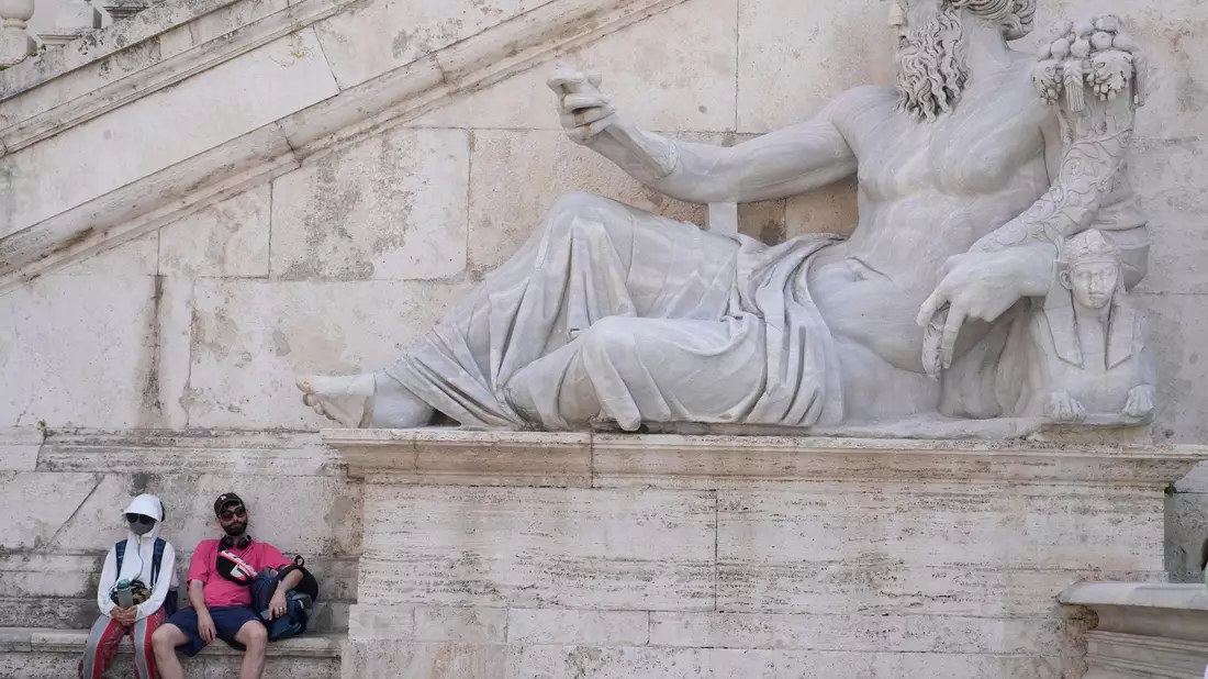 Ein Mann erfrischt sich an einem Brunnen auf dem Petersplatz, während die Temperaturen bis zu 38 Grad Celsius im Vatikan erreichen.  - Bild: Gregorio Borgia/AP/dpa